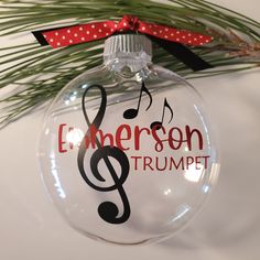 a glass ornament with a musical note and the words emerson trumpet on it