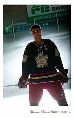 a hockey player is standing on the ice with his hands behind his back as he prepares to skate