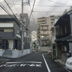 an empty street with buildings and power lines above it