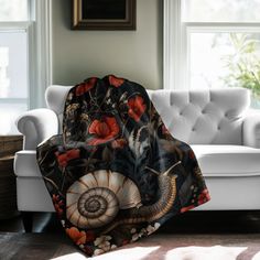 a living room with a white couch and large window covered in a black floral blanket