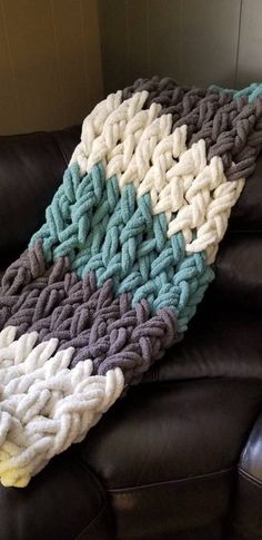 a crocheted blanket sitting on top of a leather couch