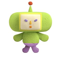 a green and yellow stuffed animal with an orange nose on it's head, standing in front of a white background