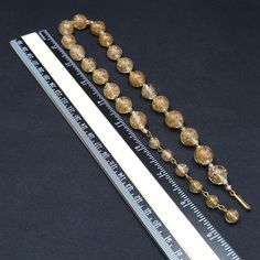 *Description: This is a beautiful clear Murano Italian glass beaded necklace made in the 1930s and filled with flecks of copper & gold which looks like glitter. Gold and copper within the beads is referred to as Aventurine. The necklace was designed with 20 12mm beads separated by clear and gold seed beads. There are six 8mm beads which are wire wrapped to add a matching extension chain. These are gorgeous Venetian beads and as a bead collector, these are one of my favorites. It is a beautif Vintage Polished Gold Beads, Vintage Gold Polished Beads, Vintage Large Gold Beads, Adjustable Vintage Gold Beaded Necklace, Vintage Clear Necklaces For Formal Occasions, Vintage Glass Beaded Necklaces, Vintage Glass Faceted Beads, Vintage Clear Round Bead Necklaces, Vintage Handmade Clear Necklace