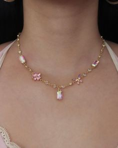 The Lily Charm Choker Necklace is a dainty necklace featuring a radiant chain with round links and five pastel-colored charms including two iridescent rectangle connectors, one butterfly connector, one flower connector, and one iridescent rectangle charm at the center.  * Length: 14.25" inches + 3" extender  * 24k & 14k gold-filled brass; cubic zirconia  * Waterproof & sweat-proof  * Handmade & made-to-order See our Jewelry Care guide. Chokers Necklace, Charm Choker Necklace, Pretty Jewelry Necklaces, One Flower, Flower Charm Necklace, Waterproof Jewelry, Sweat Proof, Jewelry Inspo, Simple Jewelry