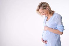 a pregnant woman holding her stomach in pain