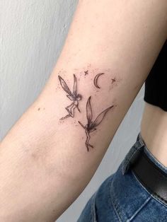 a woman with a tattoo on her arm that has two birds flying in the sky