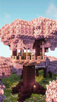 a large tree with lots of pink flowers in the middle of it and a house on top