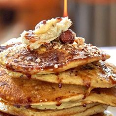 a stack of pancakes with syrup and nuts on top