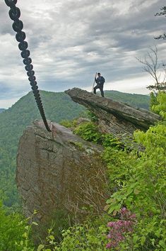 a man standing on top of a large rock