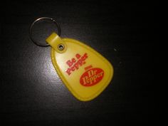 a yellow plastic keychain with the word hot dog on it's side