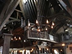 the inside of a building with wooden beams and chandeliers