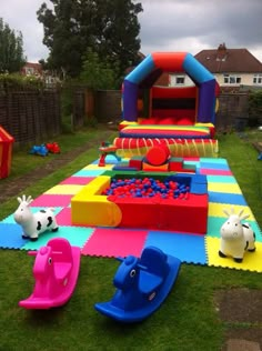 an inflatable bounce house with toys on the lawn and children's play area