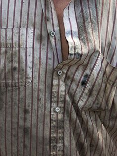 a man wearing a striped shirt with his hands in his pockets