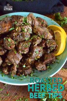 a blue plate topped with meat next to a slice of lemon and parsley on top of a wooden table