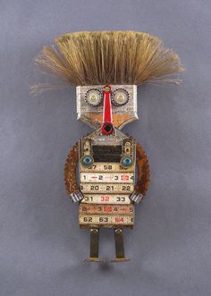 a robot made out of different types of electronics and hair on it's head