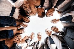 a group of people standing in a circle with their heads together looking up at the camera