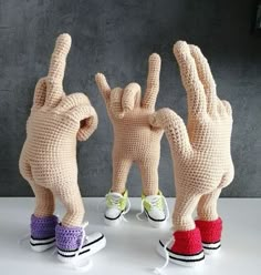 three knitted hand puppets with one holding the other's hands in front of them