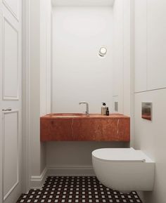 a white toilet sitting next to a sink in a bathroom