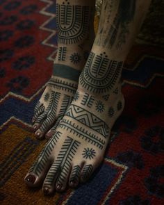 a woman's feet with tattoos on them