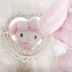 a pink stuffed animal in front of a heart shaped mirror