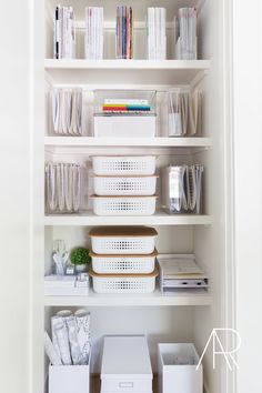 an organized pantry with white bins and plastic containers