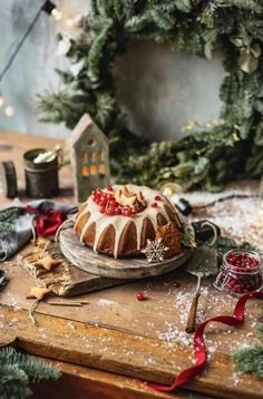 a bundt cake sitting on top of a wooden table next to christmas wreaths