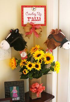 a vase filled with sunflowers and stuffed animals on top of a wooden table