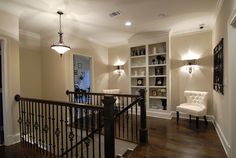 the stairs in this house are made of wood and wrought iron, with built - in bookshelves on either side