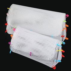 two pieces of white mesh with colorful pins on them