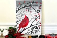 a red bird sitting on top of a tree branch next to christmas decorations and other items