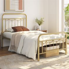 a bed with white sheets and brown pillows in a room next to a large window