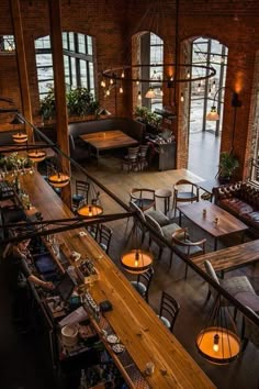 an overhead view of a restaurant with tables and chairs in the foreground, lights hanging from the ceiling