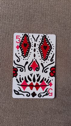 a playing card with red and black designs on it