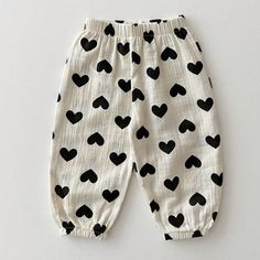 a pair of pants with black hearts on them sitting on top of a white surface