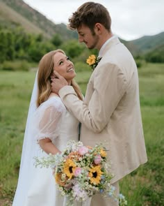 a bride and groom standing together in the middle of a field with sunflowers