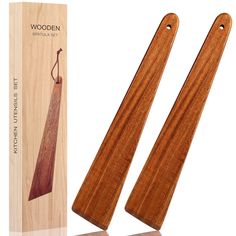 two wooden spatulas sitting next to each other in front of a box and packaging