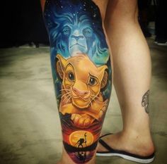 a man's leg with a lion tattoo on it and an animal in the background