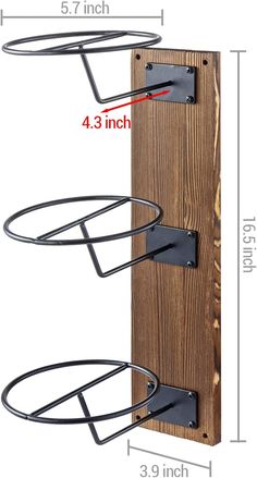 the wall mounted coat rack has three hooks on it and is attached to a wood panel