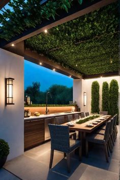 an outdoor kitchen and dining area is lit up at night with lights on the ceiling