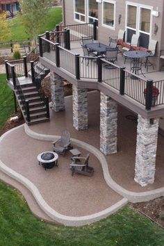 an outdoor patio with stone pillars and seating area next to a deck that is built into the side of a house