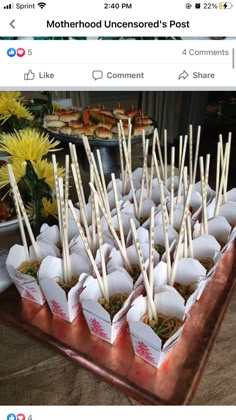 there are many small cups with sticks in them on the tray and one is filled with food