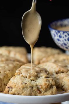 a spoon drizzling sauce onto some cookies on a plate