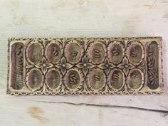 an old wooden plaque with ornate designs on it