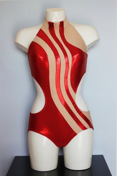 a white mannequin with red and beige stripes on it's body, sitting on a black surface