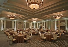 a banquet room with round tables and chandeliers