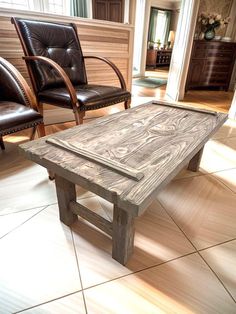 a living room with two leather chairs and a coffee table in the middle of it