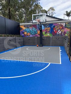 an outdoor basketball court painted with graffiti