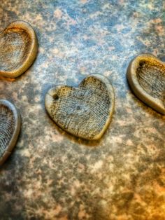 three heart shaped cookies sitting on top of a table