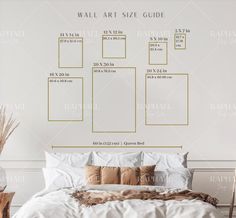 a bed with white sheets and gold pillows in front of a wall art size guide