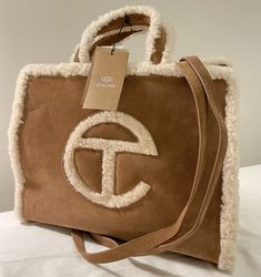 - Telfar x Ugg Limited collaboration - Was only available for a short time. Will not be restocked again. Unavailable everywhere - BRAND NEW / NEVER USED - 10/10 - Only taken out for photos - Still has tags and will send with dust bags - Authentic. Order confirmation and receipt shown - Medium size bag, larger than it looks in photos. Measurements upon request -Made with real suede in Ugg’s signature chestnut color and white shearling. Has two long shoulder straps and inside is a large pocket/zip Brown Medium Shoulder Bag With Dust Bag Included, Medium Brown Shoulder Bag With Dust Bag Included, Ugg Telfar, Telfar X Ugg, Telfar Shopping Bag, Telfar Bags, Ugg Bag, Telfar Bag, Western Outfits Men